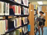 A student browses the library bookstacks.