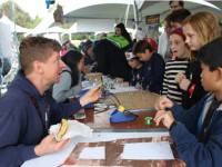 Dr. Travis Feldman, left, teaches children the art of inventing, designing, and tinkering during Maker Faire last weekend.