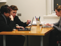 Jacob Meyers ’17 (second from left) works with a student as another tutor waits for someone to help.