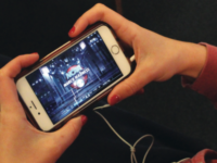 A student streams the tournament on their phone.