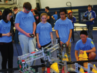 Members of the robotics team test their robot at the competition.
